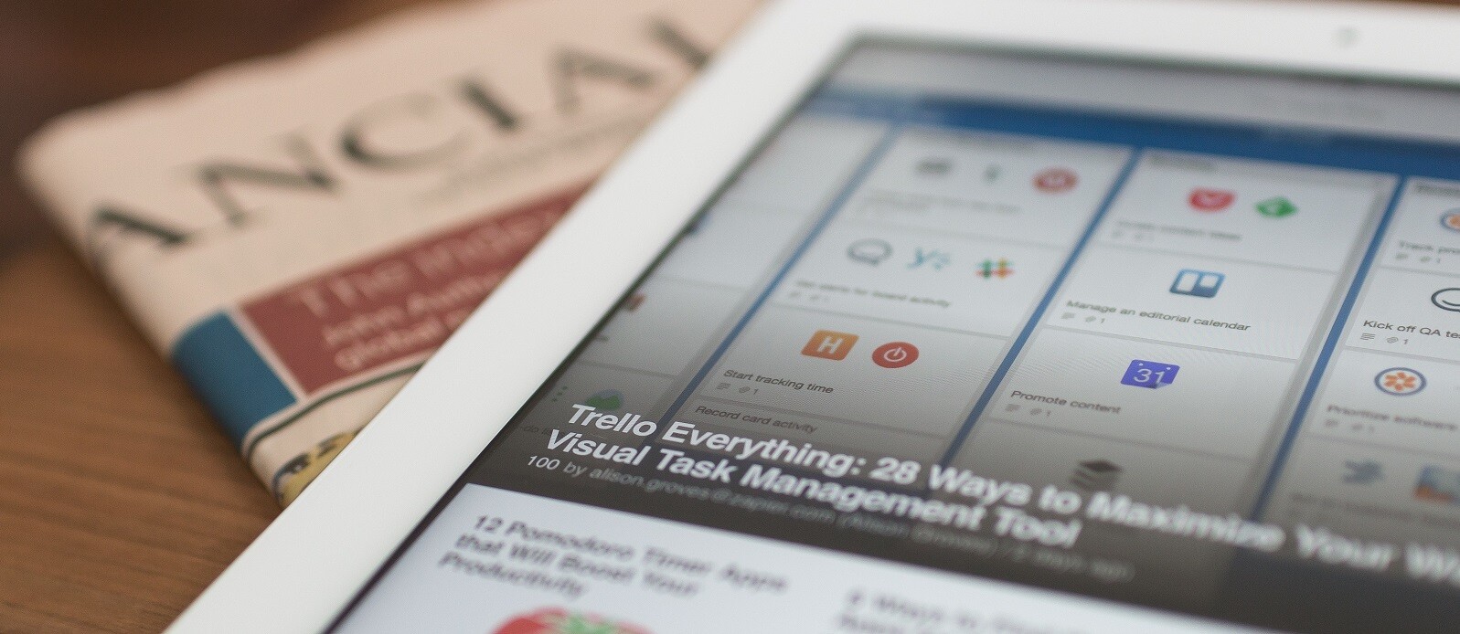 como usar o trello - tablet que mostra o trello aberto sobre um jornal